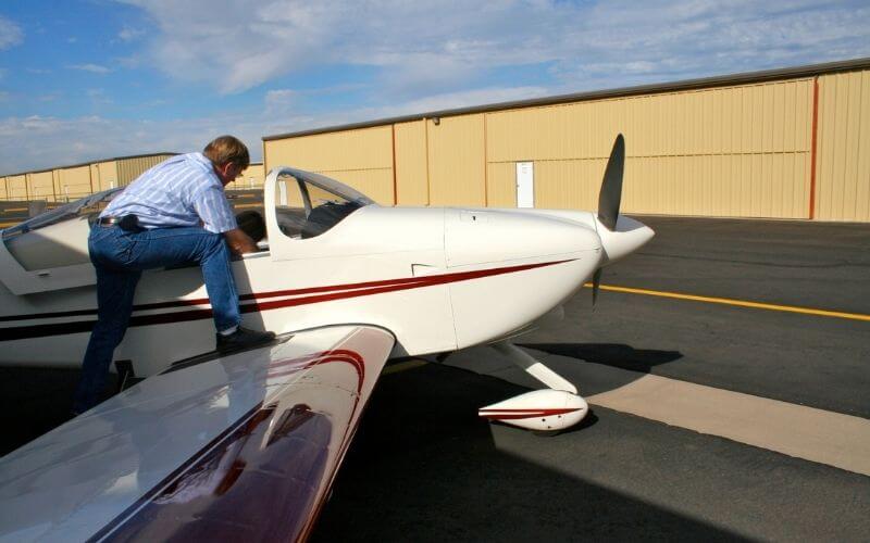 Pilot conducting a weight and balance check on a cessna airplane.